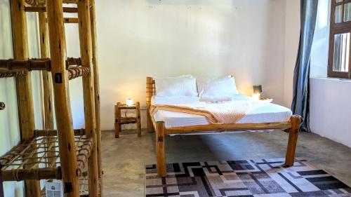 a bedroom with a wooden bed with two pillows at Kays Place Train house Jambo in Zanzibar City