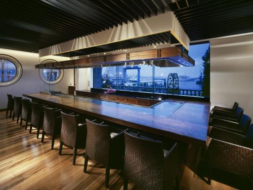 a bar in a restaurant with chairs around it at Hotel La Suite Kobe Harborland in Kobe