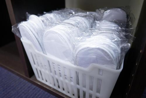 a white basket filled with lots of white dishes at Hotel Select Inn Isesaki in Isesaki