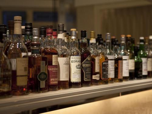 a row of bottles of alcohol on a shelf at Hotel La Suite Kobe Harborland in Kobe