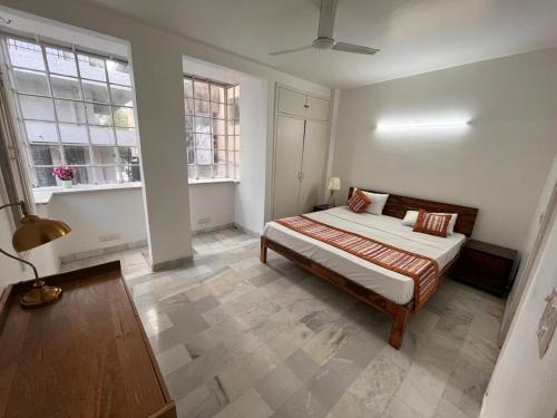 a bedroom with a bed and two windows at Giostay Residency in New Delhi