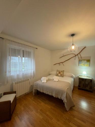 a bedroom with a bed and a chandelier at La Casa de mis Padres in Arahuetes