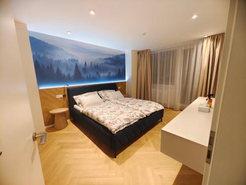 a bedroom with a bed and a large painting on the wall at Base Camp - Apartmán Klínovec in Kovářská