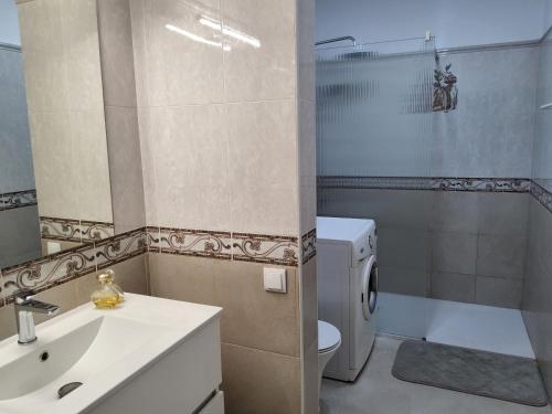 a bathroom with a sink and a toilet and a shower at Lorarno in Praia do Carvoeiro