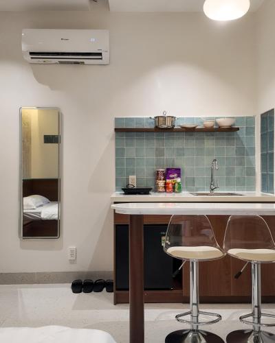 a kitchen with a sink and two bar stools at Mik Stay 2 in Danang