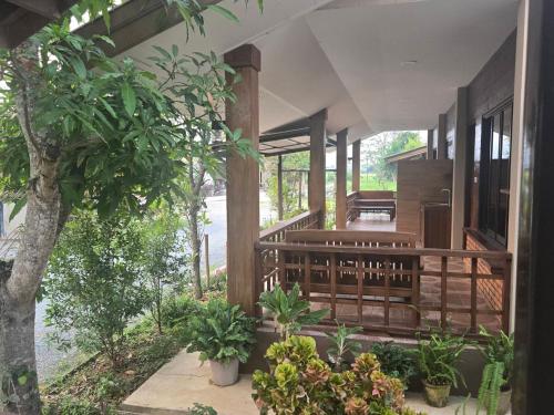 a house with a porch with trees and plants at Cocoa Hut in Mae Chan
