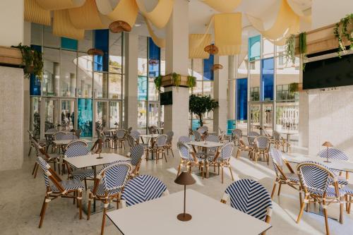 a restaurant with tables and chairs and windows at Palladium Hotel Peñiscola in Peniscola