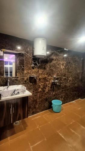 a bathroom with a sink and a light on a wall at RK Residency Hotel & Resturant in Ukhimath