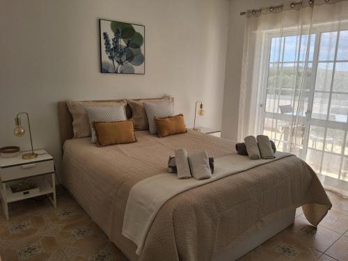 a large bed in a bedroom with a large window at Lorarno in Praia do Carvoeiro