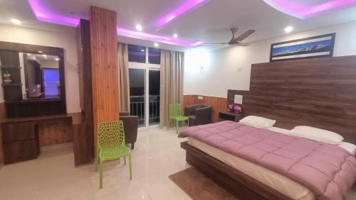 a bedroom with a purple bed and a television at RK Residency Hotel & Resturant in Ukhimath