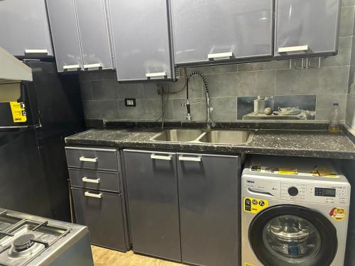 a kitchen with a sink and a washing machine at Kimka in Aswan
