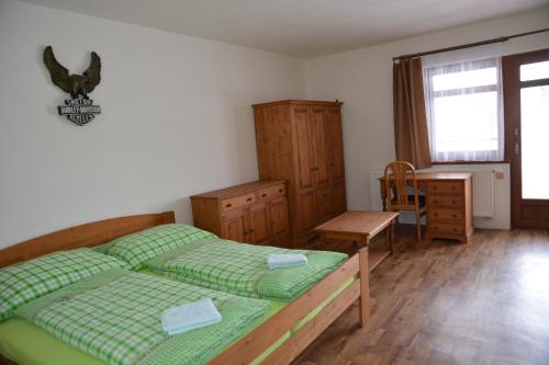 a bedroom with a bed and a chair and a window at Hotel HAVLOV in Žďárec