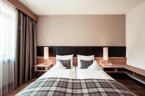 a bedroom with a large bed with two pillows at SIEGI apartments & retreat - Merano Südtirol in Parcines