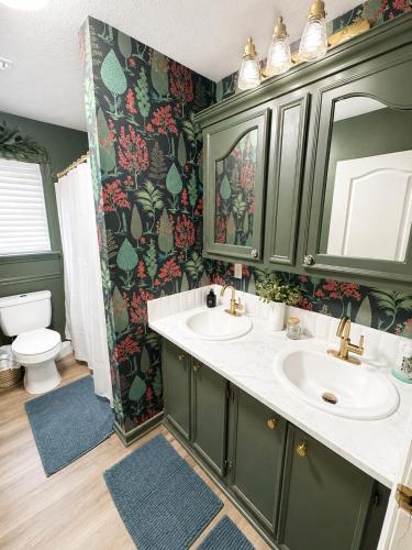 a bathroom with two sinks and a toilet at Peach Door Cottage in Lufkin