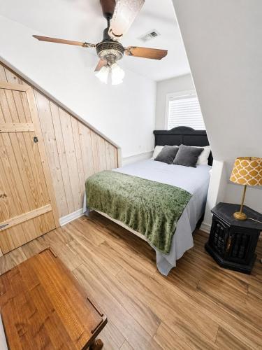 a bedroom with a bed and a ceiling fan at Peach Door Cottage in Lufkin