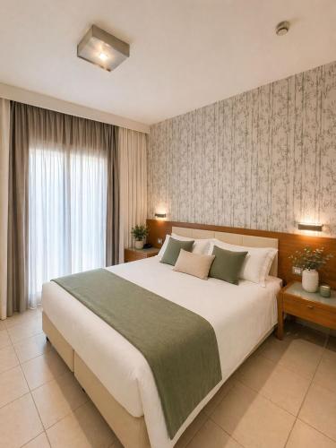 a bedroom with a large white bed and a window at Hotel La Costiera in Varcaturo