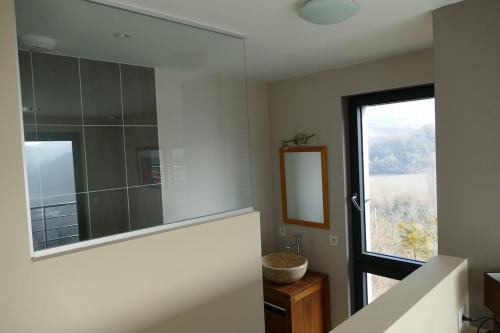 a bathroom with a large mirror and a window at Villa d'architecte avec vue imprenable in Cobonne