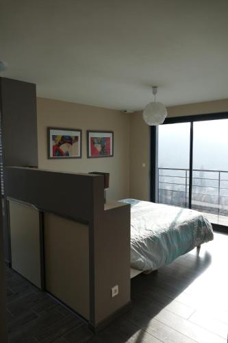 a bedroom with a large bed and a large window at Villa d'architecte avec vue imprenable in Cobonne