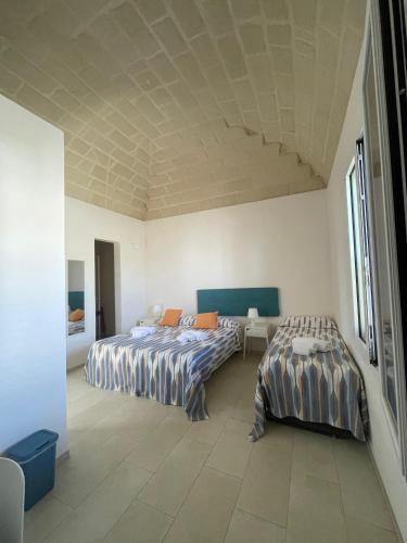 a bedroom with two beds and a table in it at Le Muciare in Favignana