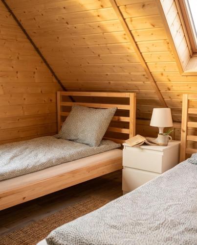 a bedroom with two beds in a wooden cabin at Domki Hippalos Jarosławiec in Jarosławiec