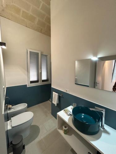 a bathroom with a blue sink and a toilet at Le Muciare in Favignana