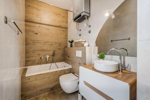 a bathroom with a sink and a tub and a toilet at Villa Ventula in Šuljkove Kuće