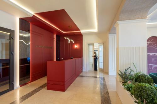 a hallway with red walls and a woman in the background at Hotel Apolodor in Orşova