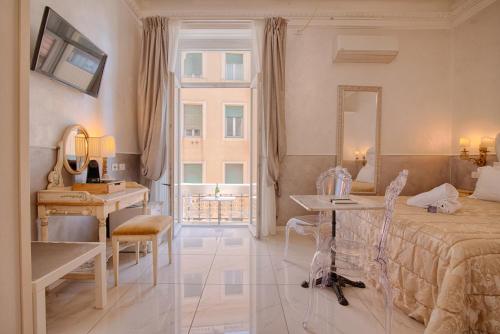 a bedroom with a bed and a desk and a mirror at Home Grifondoro Affittacamere in Genoa