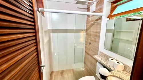 a bathroom with a shower and a toilet and a mirror at Pousada Angellus in Paraty