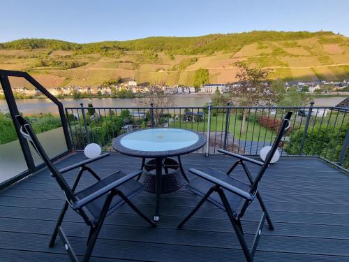 a patio with a table and chairs on a deck at Zum Blauglockenbaum in Zell an der Mosel