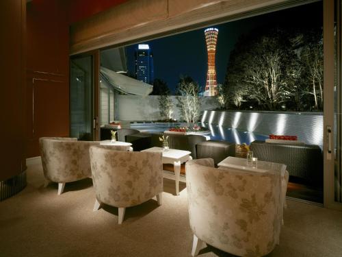 a restaurant with tables and chairs and a view of a city at Hotel La Suite Kobe Harborland in Kobe