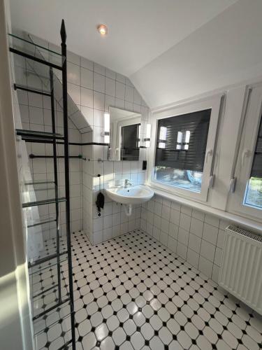 a white bathroom with a sink and a mirror at FeWo Bispingen in Bispingen