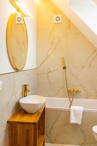 a bathroom with a sink and a mirror and a tub at Przystanek Babia Apartamenty in Lipnica Wielka