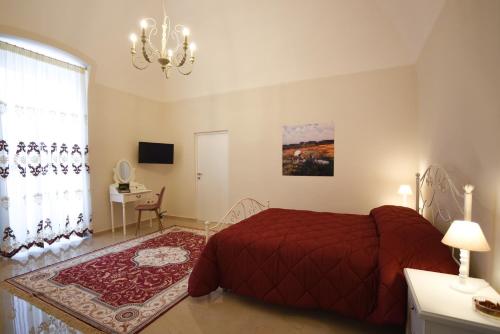 a bedroom with a red bed and a chandelier at KAPSOTT B&B in Bisceglie