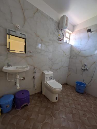 a bathroom with a toilet and a sink at Shree's Seaside Homestay - Sea Pearl in Magdāl