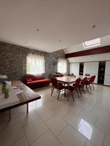 a large living room with a table and chairs at Villa avec piscine intérieure, proche Strasbourg in Holtzheim