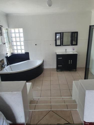 a bathroom with a bath tub and a sink at 1krom str bellville boston in Bellville