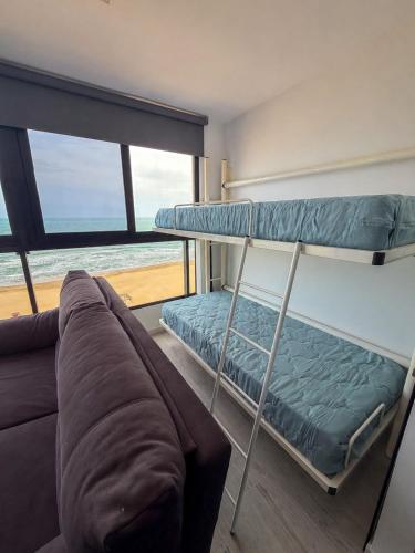 a room with two bunk beds and a couch at Espacio I in Cullera