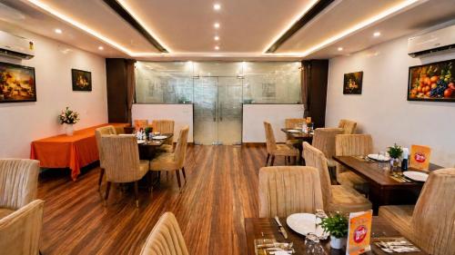 a restaurant with wooden floors and tables and chairs at Hotel Kian by JMD Group in New Delhi