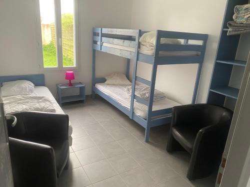 a room with two bunk beds and a chair at hirondelle 1 in Noirmoutier-en-l'lle