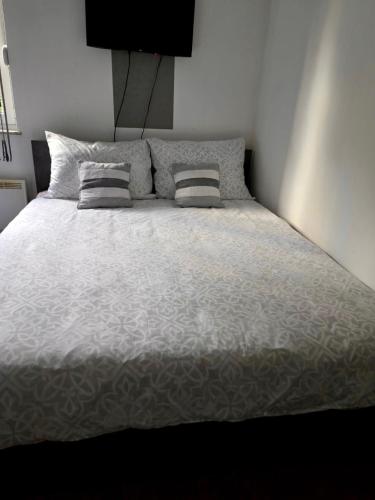 a bed with two pillows on it in a bedroom at Apartman Wegele in Teslić