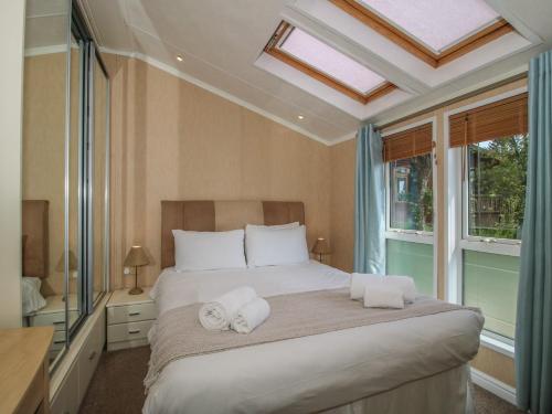 a bedroom with a large bed with towels on it at Daisy in Leominster
