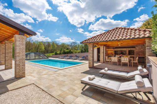 a patio with a swimming pool and a house at Lux pool Villa Zen - located in peaceful village near Rijeka and Opatija in Klana