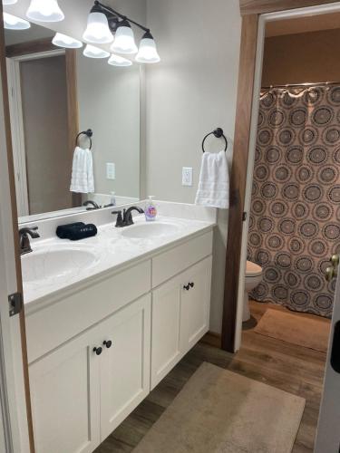 a bathroom with a white sink and a mirror at Restored 1800s Farmhouse on Working Sheep Farm in Bird-in-Hand