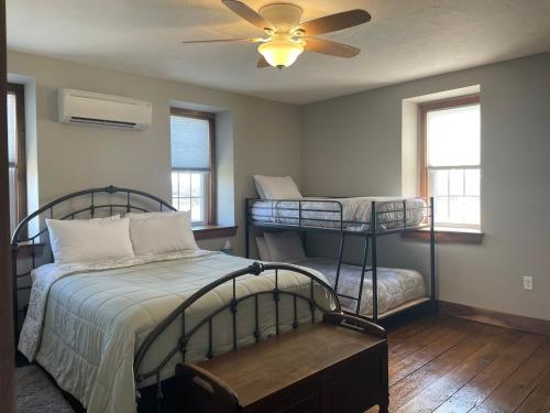 a bedroom with two bunk beds and a ceiling fan at Restored 1800s Farmhouse on Working Sheep Farm in Bird-in-Hand