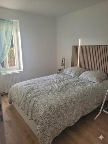 a bedroom with a bed and a window at Appartement cosy in Commentry