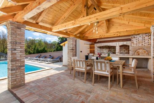 a patio with a fireplace and a table and chairs at Lux pool Villa Zen - located in peaceful village near Rijeka and Opatija in Klana
