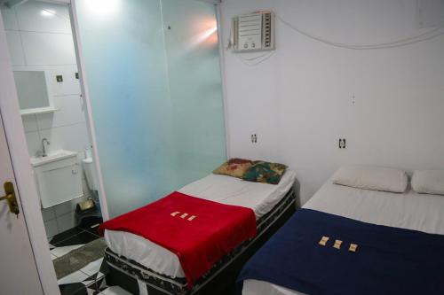 a small room with two beds in a room at Donwtonw in Arraial do Cabo