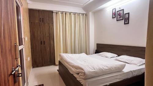 a small bedroom with a bed in a room at Premium 2BHK near Kainchi Dham in Bhowāli