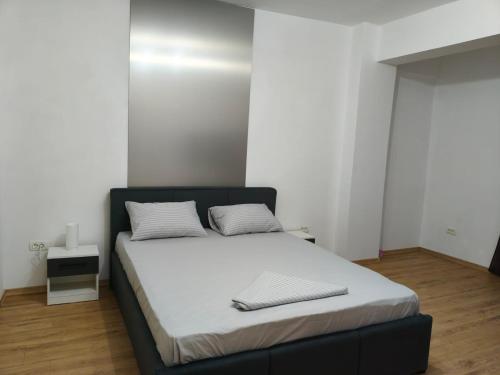 a bedroom with a bed with white sheets and white pillows at Voievozilor Residence in Constanţa